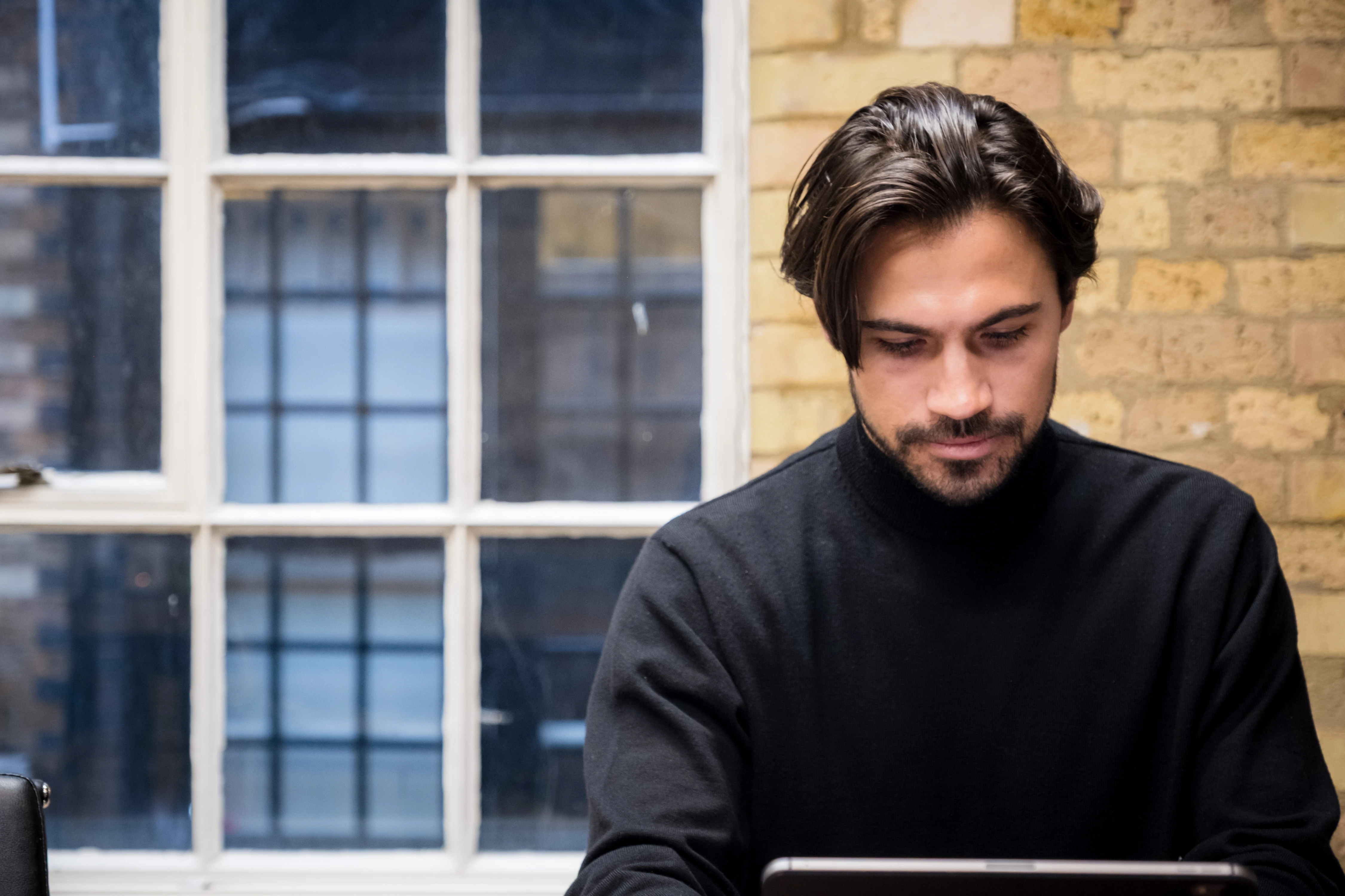 Backed VC - Founding partner working at a laptop, natural window light