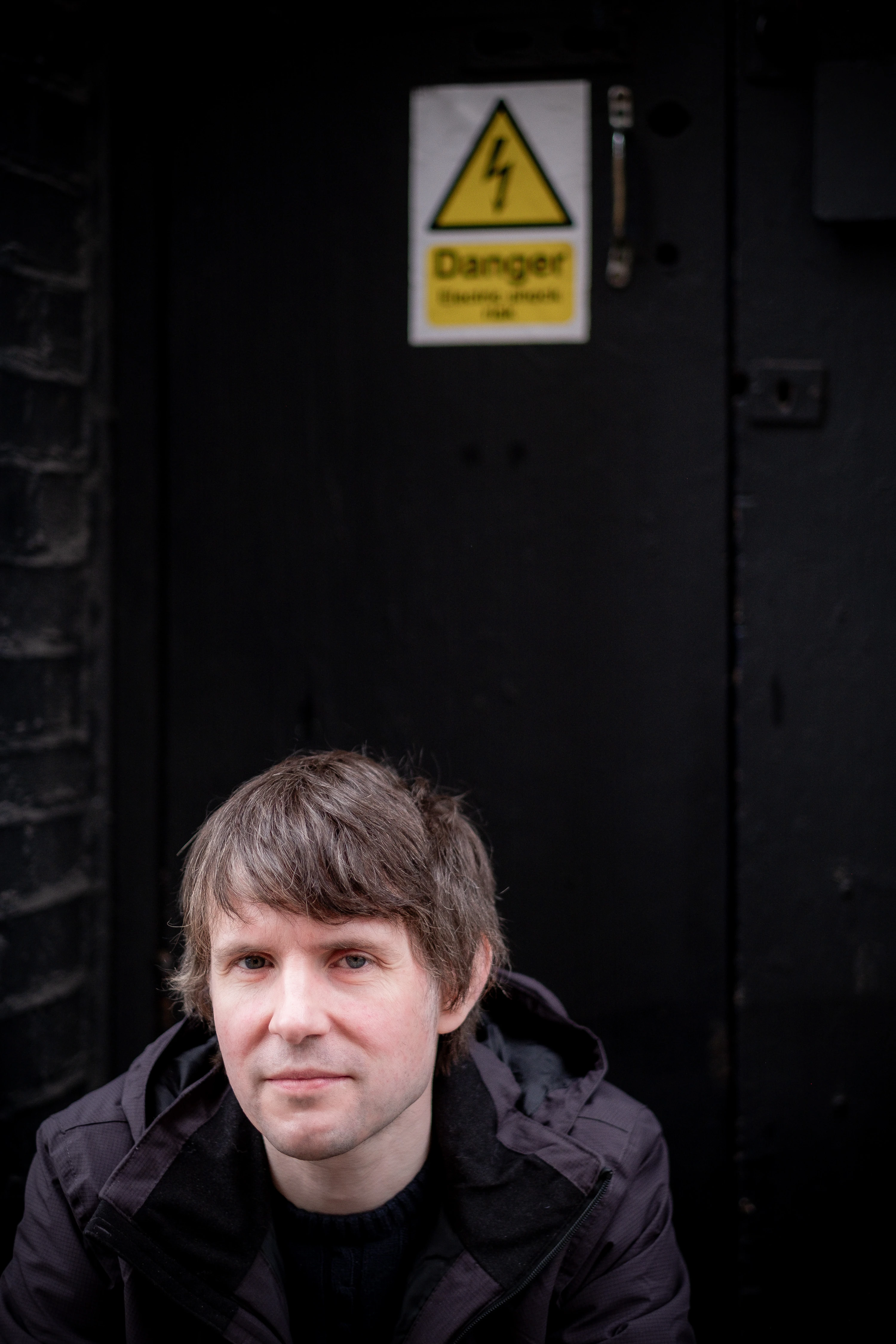 Martin Bryant Personal Branding Headshots - Portrait against industrial door, danger sign detail