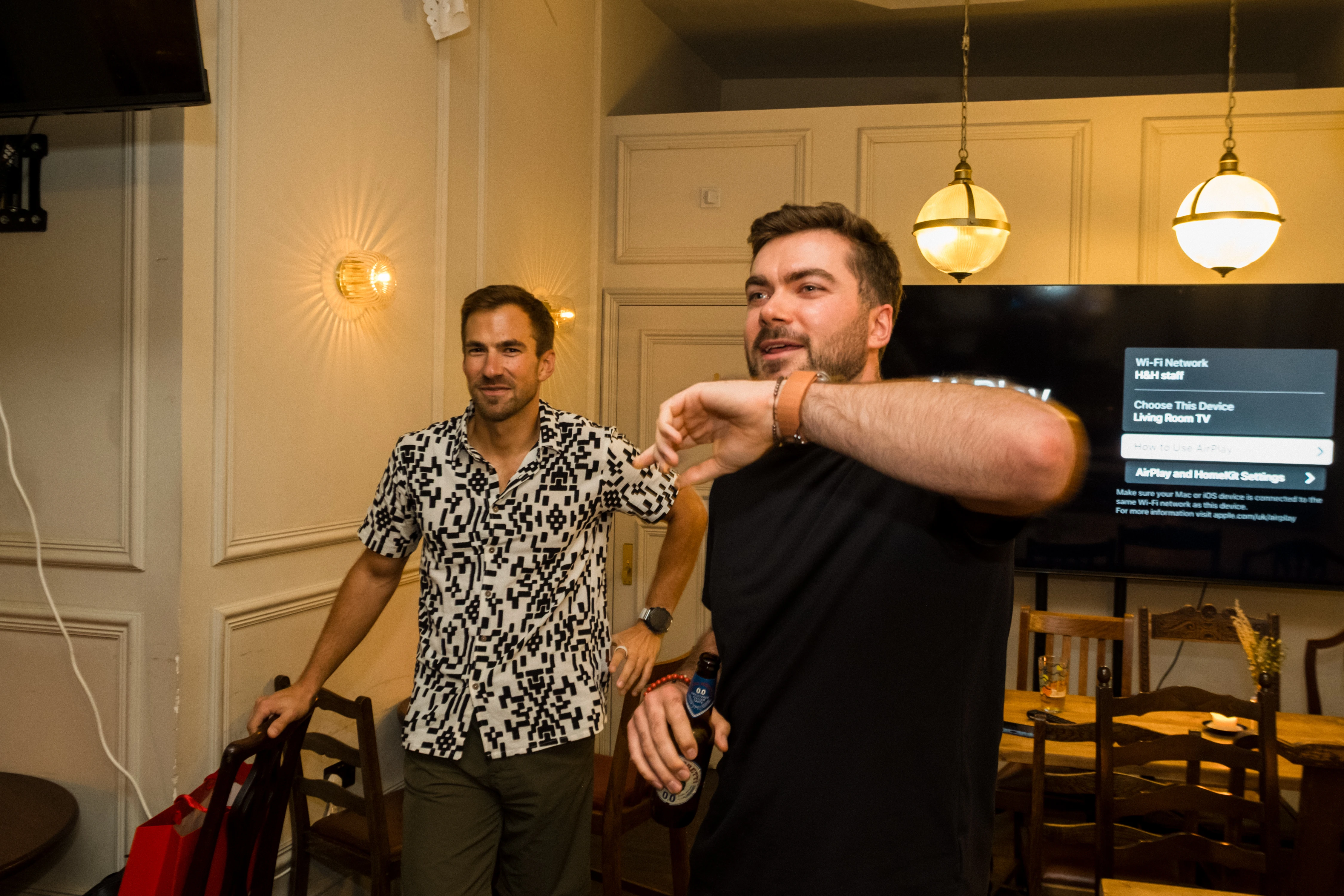 Planet A Ventures Meetup London - Two attendees mid-banter beneath pendant lamps in the private room