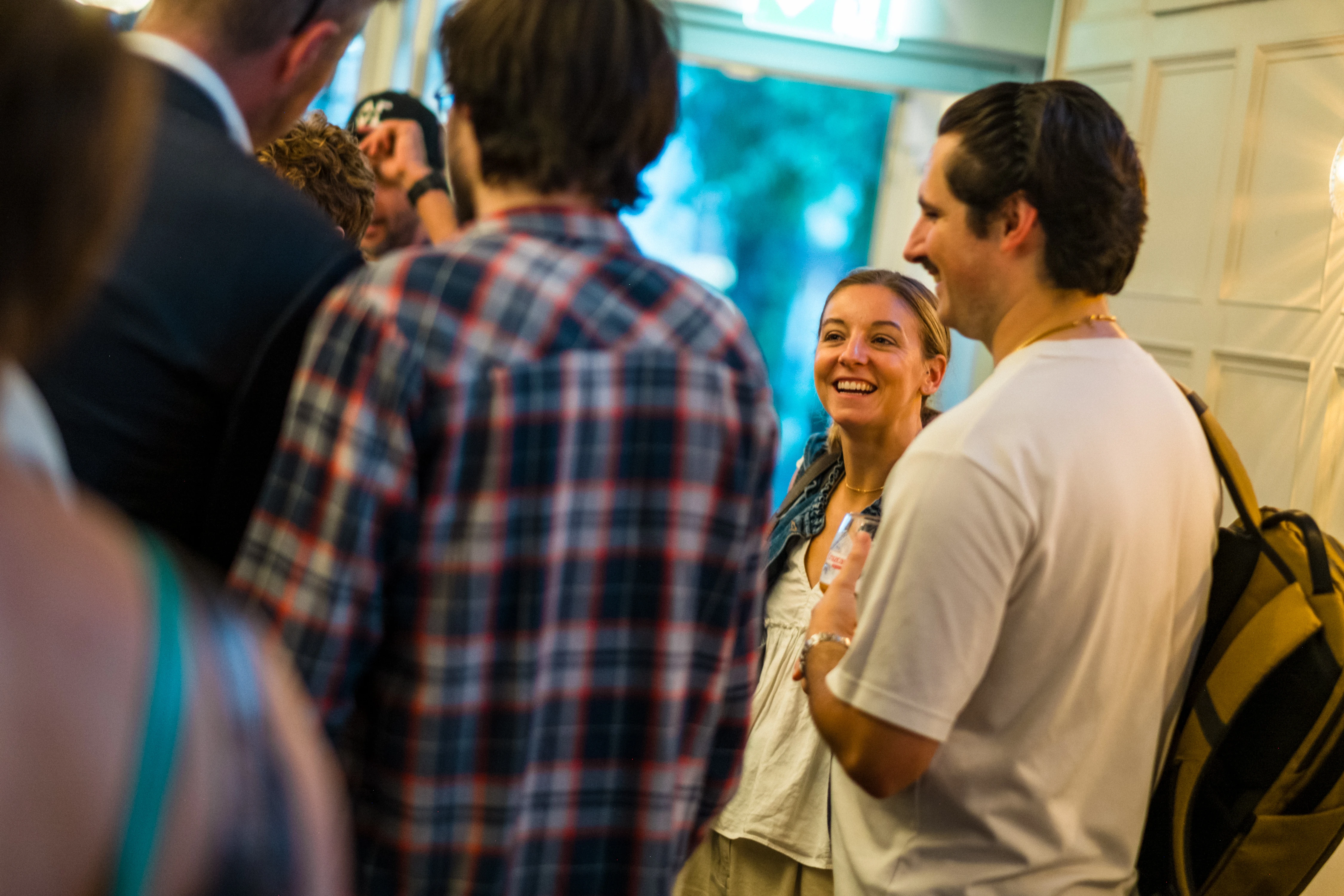 Planet A Ventures Meetup London - Two guests share a laugh in the crush of the room