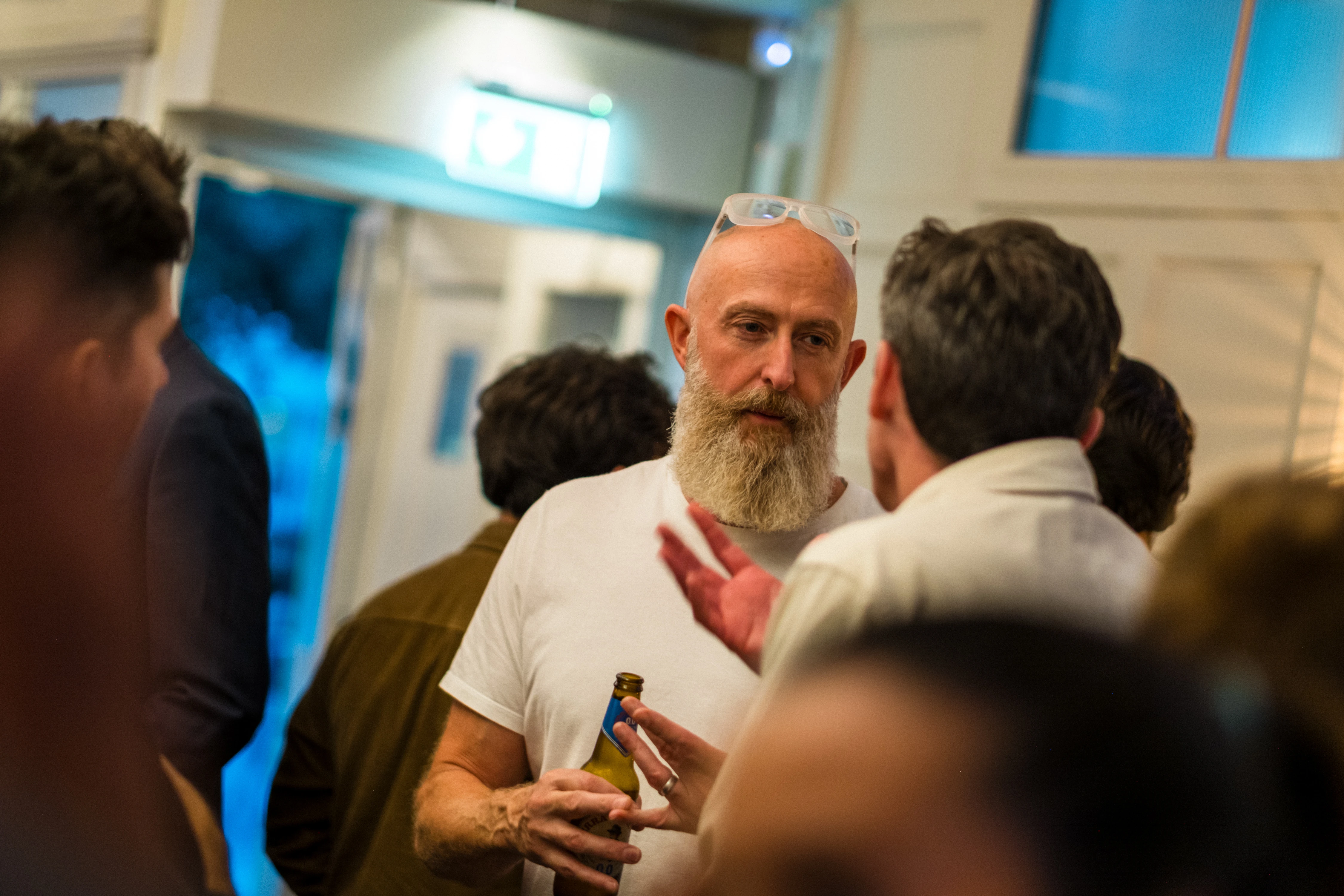 Planet A Ventures Meetup London - Candid conversation, one guest mid-gesture with a bottle in hand